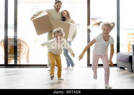 Funny happy kids exécutant dans nouvelle maison le jour du déménagement Banque D'Images