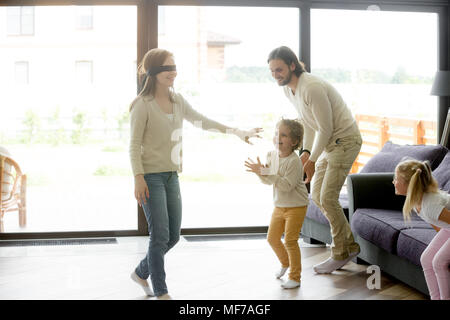 Les enfants de la famille joue à cache-cache jeu avec maman les yeux bandés Banque D'Images