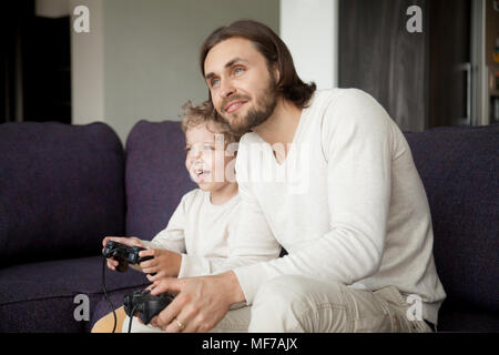 Père et fils tenant une manette de jeu vidéo jeu bénéficiant d'ensemble Banque D'Images