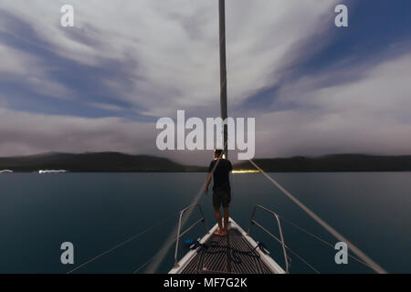 L'Indonésie, l'île de Lombok, l'homme sur le pont d'un bateau à voile au crépuscule Banque D'Images