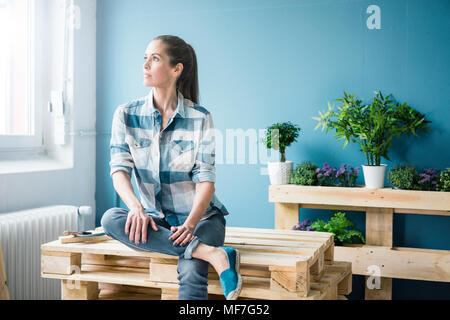 Belle femme qui projette de rénover sa maison avec des palettes Banque D'Images