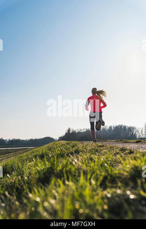 Jeune femme tournant sur chemin rural Banque D'Images