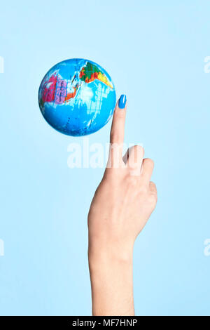 Close-up of globe next to woman's finger Banque D'Images