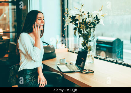 Happy young businesswoman au téléphone dans un coffee shop Banque D'Images