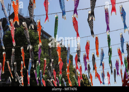 De nombreux poissons de papier coloré ou de lanternes en papier accrocher sur les cordes en diagonale au-dessus de l'afficheur contre un ciel bleu ; célébrer la Fête des enfants au Japon. Banque D'Images