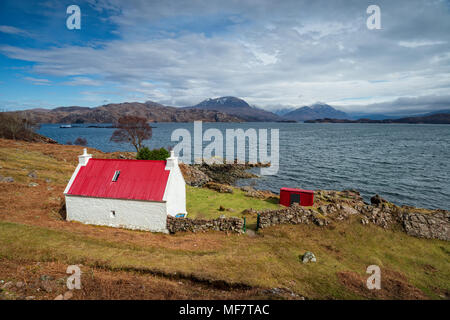 Une jolie maison avec un toit rouge sur les rives du Loch Shieldaig en Ecosse et sur le NC500 route touristique côtière Banque D'Images