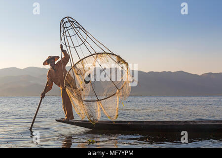 Pêcheur d'aviron de jambe Intha à Shan State, Inle Lake, Myanmar (Birmanie), Asie en février - pêcheur tenant le filet conique avec des poissons pêchés Banque D'Images