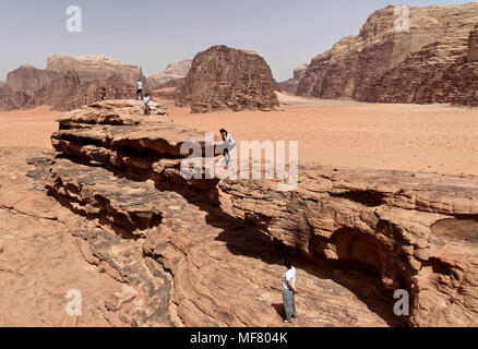 Wadi Rum, Jordanie, 8 mars 2018 : les touristes en provenance de Chine et l'Europe monter le célèbre pont de pierre dans le désert nature reserve Banque D'Images