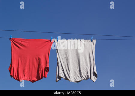 Rouge et gris T-shirts sur Vêtements en ligne avec ciel bleu copie espace. Banque D'Images