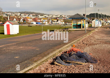 Les filets de pêche et le sable rejetés sur la promenade par des tempêtes. Banque D'Images