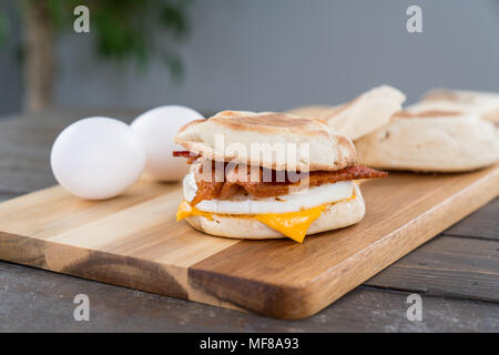 Bacon, oeufs et fromage sandwich déjeuner muffin anglais avec on cutting board Banque D'Images