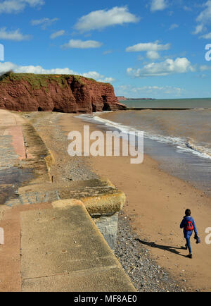 Un promeneur solitaire sur une plage déserte à Langstone Rock. Banque D'Images