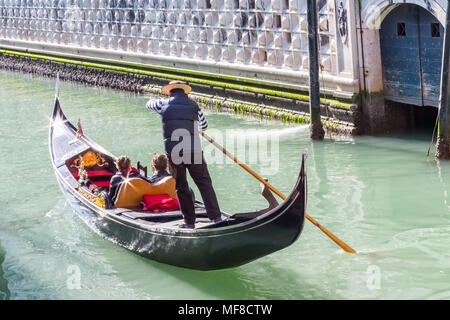 Venise, Italie - 28 Février 2015 : un gondolier steers un couple vers le bas d'un canal à Venise, Italie sur une journée d'hiver ensoleillée. Banque D'Images