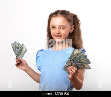 Happy smiling girl holding pour enfants riches de l'argent dans la main avec émotion naturelle visage sur fond blanc Banque D'Images