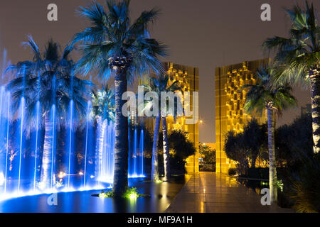 Al Shaheed Park, le Koweït. Fontaine de nuit de demain. Constitution monument à l'arrière-plan. Banque D'Images