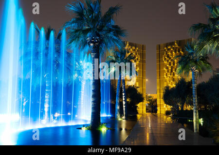 Al Shaheed Park, le Koweït. Fontaine de nuit de demain. Constitution monument à l'arrière-plan. Banque D'Images