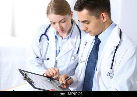 Rédaction d'articles de médecins en utilisant le presse-papiers. Les médicaments médecins qui discutent du programme ou de l'étudiant à la conférence médicale. Les soins de santé, l'assurance et medicine concept Banque D'Images