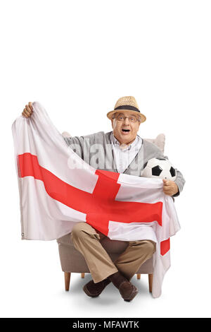 Personnes âgées excité fan de foot assis dans un fauteuil et tenant un drapeau anglais isolé sur fond blanc Banque D'Images