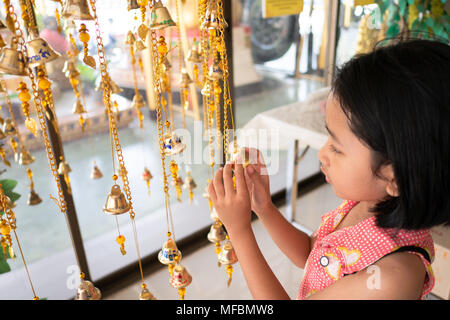 Les mains des filles sont liés à l'or des cloches de la foi bouddhiste. Les croyances, les Thaïlandais s'écrit sur la lettre des cloches, aura de la chance. Temple thaï, Sel Banque D'Images