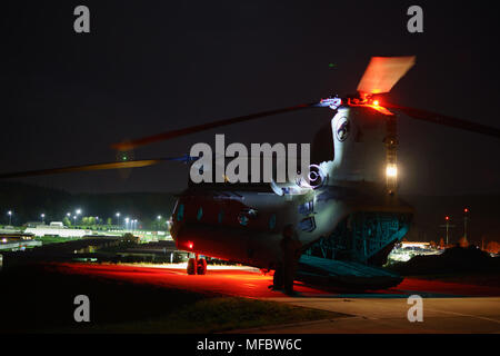 Le s.. Fitz Hall, un hélicoptère CH-47 Chinook de l'équipage de la société B, 2e Bataillon de l'aviation d'appui général, 227e Régiment d'aviation, 1st Air Cavalry Brigade, Division de cavalerie, jette un éclairage sur la queue de l'hélicoptère pendant les vérifications prévol avant une mission d'assaut de nuit à Hohenfels Domaine de formation, l'Allemagne, le 23 avril 2018. Les équipages de la compagnie s'est associé avec des soldats du 1er bataillon du 503e Régiment d'infanterie, 173e Brigade aéroportée, de former et de tester de nouveaux concepts pour les soldats au cours de l'évaluation militaire interarmées 18, un exercice qui augmente la force d'avenir, l'état de préparation Banque D'Images