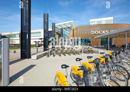 Bruxelles, Belgique, 19 avril 2018 : Stock de vélo de location et certaines personnes se reposant sur les Docks Bruxsel Entrée principale - nouveau quartier commercial, dans une zone Banque D'Images