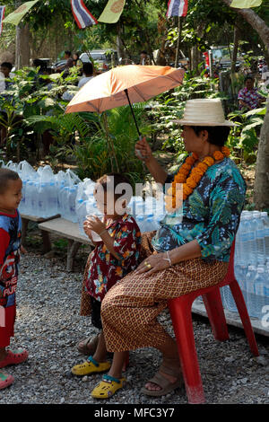 Grand-mère en Thaïlande et les vêtements de fête et deux enfants assis avec parapluie dans jardins du temple sur Songkran Day 2018, Udon Thani, Thaïlande Banque D'Images