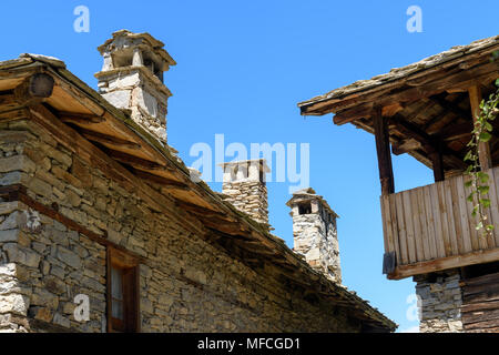Authentique ancienne maisons rustiques en pierre de brique et pierre de toits en ardoise Kovachevitsa, la Bulgarie contre ciel sans nuages en journée ensoleillée Banque D'Images