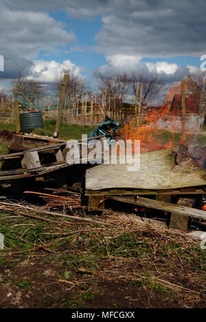 Les palettes de bois et déchets général d'être brûlé sur un allotissement Banque D'Images