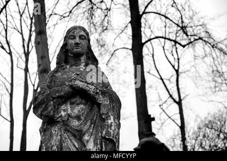 Ancienne statue en béton de la Vierge Marie au cimetière Rasos à Vilnius, Lituanie. Image en noir et blanc Banque D'Images