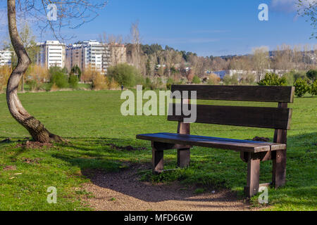 Banc de jardin vide sur Parque da Devesa parc urbain à Vila Nova de Famalicão, Portugal. Construit à proximité du centre de la ville. Vue d'un champ vert pelouse Banque D'Images