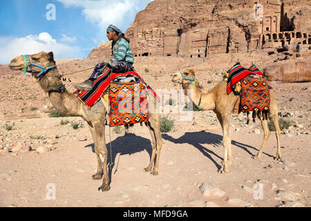 Un chamelier monté sur un chameau dans le contexte des anciennes ruines de la ville de Petra, Jordanie Banque D'Images
