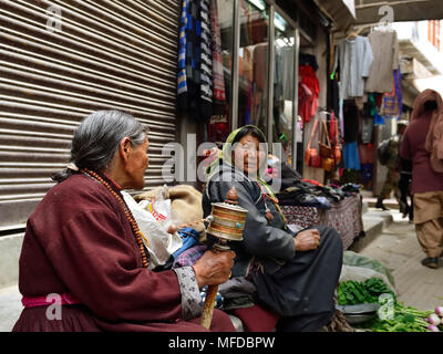 TIBET, Leh, Ladakh, INDE - 03 juillet 2017 : femme bouddhiste la vente de légumes dans les rues de Leh avec la meuleuse à main dans la prière tibétain Banque D'Images