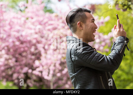 Londres, Royaume-Uni. 25 avril, 2018. Météo France : les habitants et les touristes profiter de la luxuriante cherry blossom rose comme il pics sur un après-midi ensoleillé dans le parc de Greenwich. Crédit : Guy Josse/Alamy Live News Banque D'Images