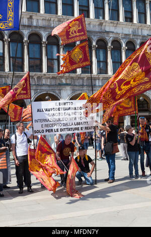 Venise, Vénétie, Italie. 25 avril 2018. Festivités de la Place St Marc marquant le jour de la libération (Festa della Liberazione) commémoration de la fin de la Seconde Guerre mondiale et l'occupation nazie de l'Italie et commémorant leurs soldats tombés. Pour Venise c'est aussi la fête de Saint Marc (Festa di San Marco) le saint patron de la ville marquant l'anniversaire de sa mort. Avec la bannière du groupe démontrant pour la libération de Venise de l'Italie sur la Piazza San Marco. MCpics Crédit/Alamy Live News Banque D'Images