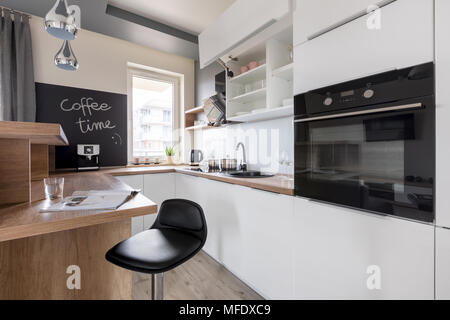 Cuisine en bois blanc, de l'unité de comptoir, noir tabouret et tableau Banque D'Images