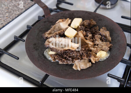 La cuisine d'être frugal morilles poêlées au beurre de conserver la saveur, coupé en deux et lavées avant chauffage acier solide sur plus de tawa tava flamme de gaz. Banque D'Images