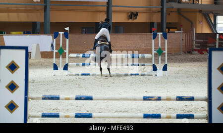 Jeune femme rider sur l'étalon sorrel sautant sur la concurrence de saut d'obstacle Banque D'Images