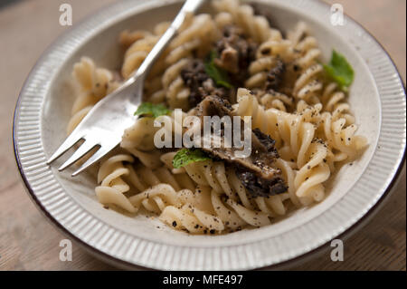 Morilles frit fraîchement cueillies dans le beurre servi avec des pâtes fusillis et un soupçon d'herbes, de poivre, de menthe délicatesse printemps frugal Banque D'Images