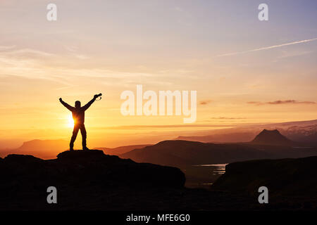 Silhouette d'un homme au sommet d'une montagne. Personne silhouette sur le rocher. Le sport et la vie active concept Banque D'Images