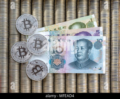 Crypto argent bitcoin BTC, le papier monnaie yuan chinois. Les pièces métalliques sont disposés dans un bon contexte à l'autre, close-up vue depuis le haut, crypto Banque D'Images