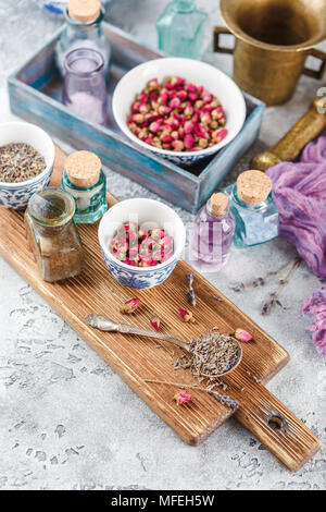 Assortiment d'herbes médicinales à sec les bourgeons roses et la lavande dans des bols. Banque D'Images