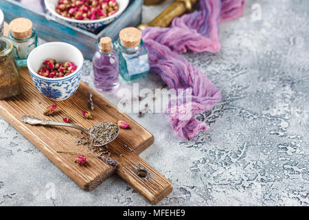 Assortiment d'herbes médicinales à sec les bourgeons roses et la lavande dans des bols. Banque D'Images