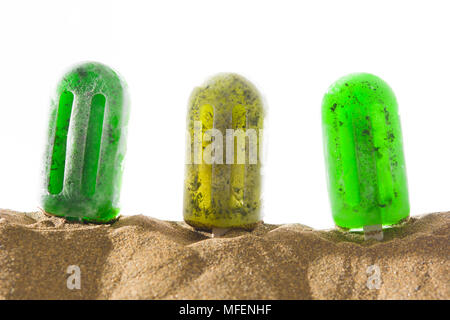 Les popsicles congelés vert dans le sable et fond blanc Banque D'Images