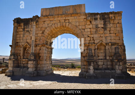 Scenic vue avant de l'Arc de Triomphe consacré à l'empereur Caracalla à Volubilis ruines romaines (Fès-Meknès, Maroc) Banque D'Images