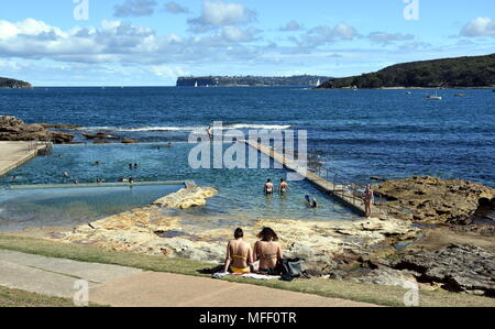 Fairlight beach sur une journée ensoleillée en été. Les gens profiter de la fraîcheur de l'eau dans une piscine de marée Fairlight. Tête du sud et Dobroyd tête dans l'arrière-plan. Banque D'Images