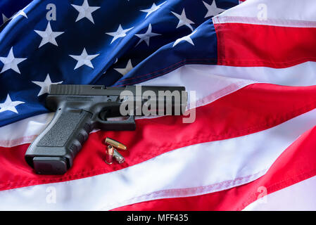Un pistolet et des balles sur le drapeau américain. Banque D'Images