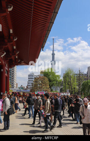 Entrez les foules à travers le complexe de Temple Sensoji Kaminarimon Gate à Centre Commercial Nakamise-dori sur une journée ensoleillée au Japon Tokyo Skytree ; dans l'arrière-plan, nuages. Banque D'Images