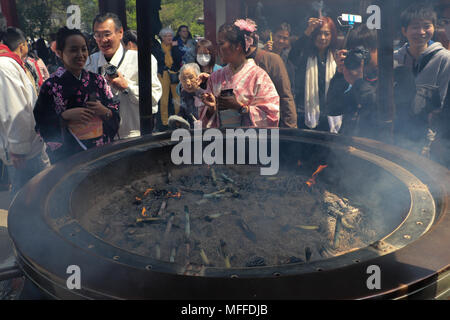 Les gens se rassemblent autour de l'Jokoro ou encens au Temple Sensoji à Tokyo, Japon. Ils waft la fumée au-dessus d'eux-mêmes, de purifier, accélérer la guérison. Banque D'Images