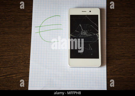 Smartphone avec un écran cassé sur une feuille de papier avec l'inscription Euro. L'enregistrement Banque D'Images