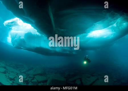 Scuba Diver sous et entre les formations de glace, le lac Sassolo, Sambuco valley, Tessin, Suisse Banque D'Images